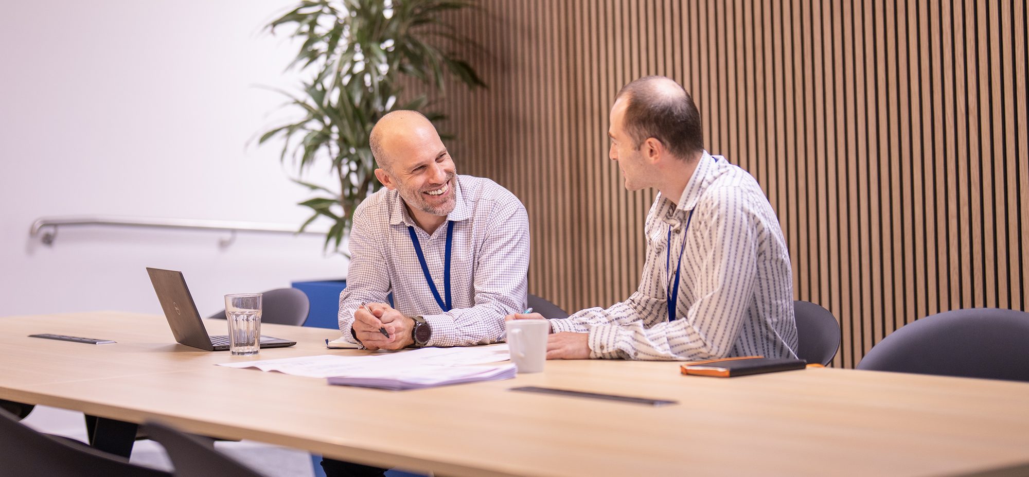 Two experienced Frazer-Nash colleagues talking in a meeting room